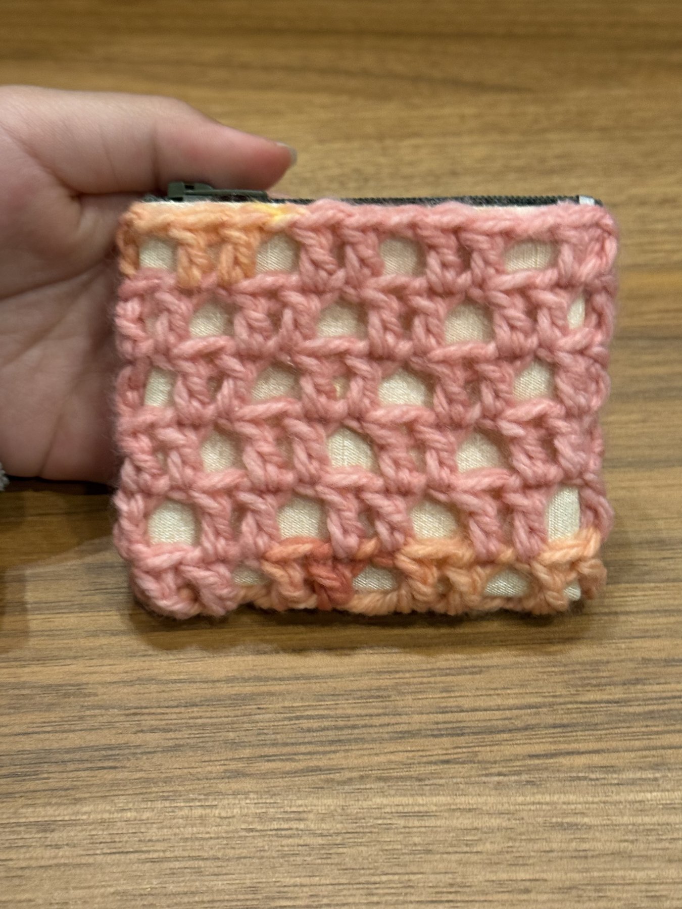 Pink open-weave crochet coin purse with yellow trim and zipper